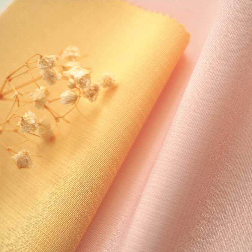 アクセントカラーカーテンの生地アップです。薄手でフラットな生地です。オレンジとピンク。