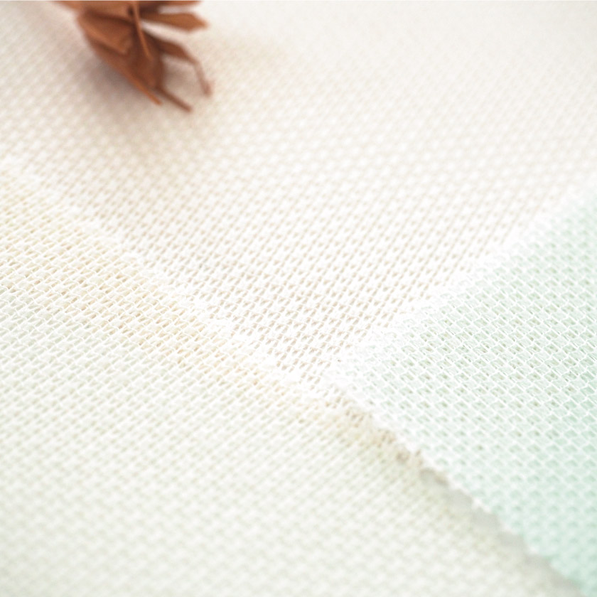 「防炎仕様のカラーレース」の生地アップです。うっすらと色味がついています。