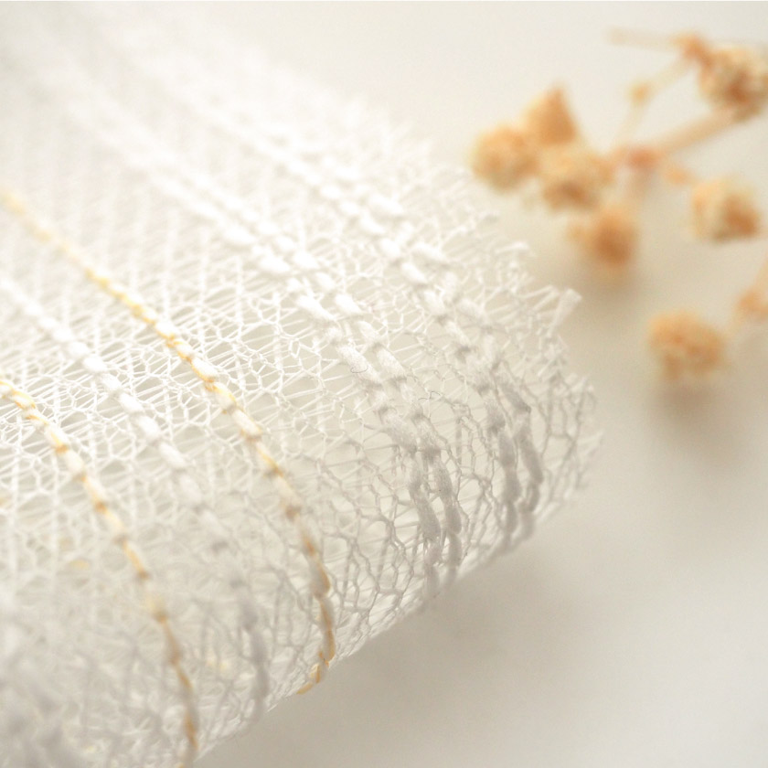 「ナチュラル感に上品さが加わったレース」の生地アップです。ストライプの糸は白とオレンジです。