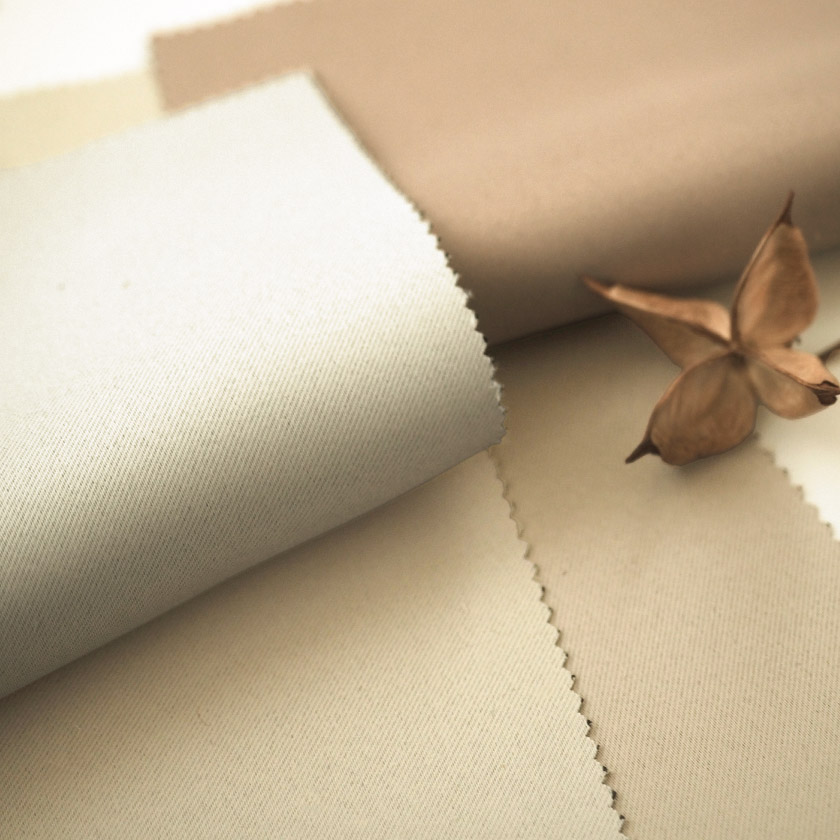 ホワイト、アイボリー、ベージュ、ライトブラウンの生地のアップ画像です。生地は非常に滑らかで、手に触れた瞬間に心地よさを感じられる柔らかな質感が特徴です。