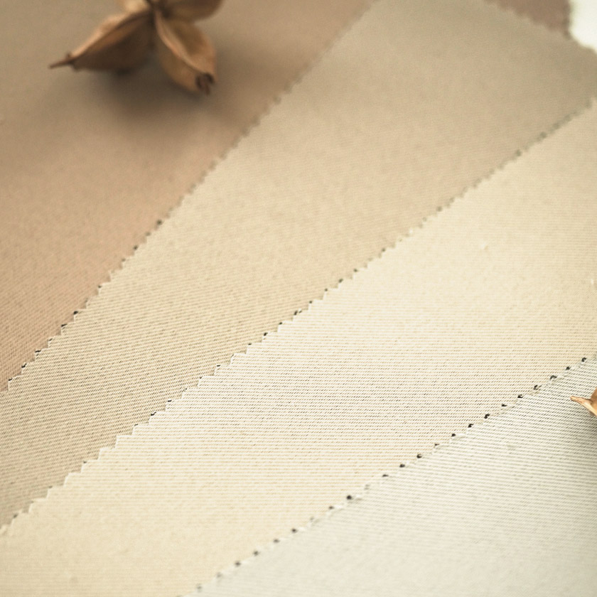 ホワイト、アイボリー、ベージュ、ライトブラウンの生地のアップ画像です。生地は目が詰まり、丁寧に織りあげられています。