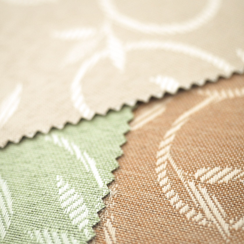 生地のアップ画像です。同系色で織り込まれた唐草柄は、主張しすぎず控えめでありながら、光の当たり方によってふわりと浮かび上がり、上品なアクセントとして美しく映えます。